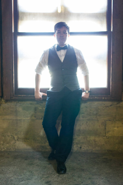 Joven hombre transgénero en ropa formal posa en una ubicación urbana gruñona
 - Foto, Imagen