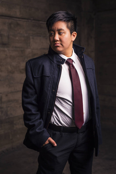 Transgenre homme en chemise et cravate pose dans un endroit grognon
 - Photo, image