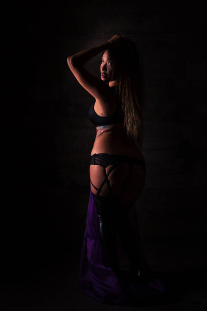 Young Pacific Islander woman in black lingerie posing in a grungy location - Photo, Image