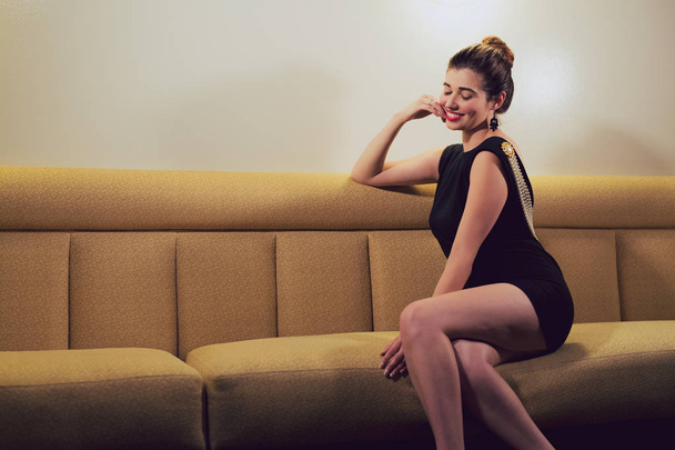 Young caucasian woman dressed in mid century fasion poses in an empty bar - Photo, Image
