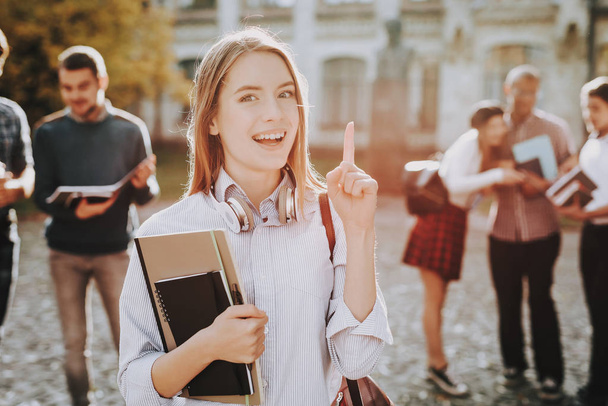 Intelligence. Thumb Up. Girl. Happy. Students. Courtyard. Books. Standing in University. Good Mood. University. Knowledge. Architecture. Happiness. Diploma. Celebration. Campus. Man. Friends. - Foto, imagen