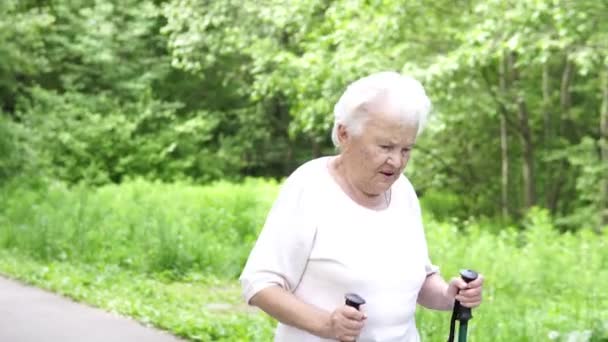 grootmoeder wandelingen met Nordic walking stokken oud grijs - Video