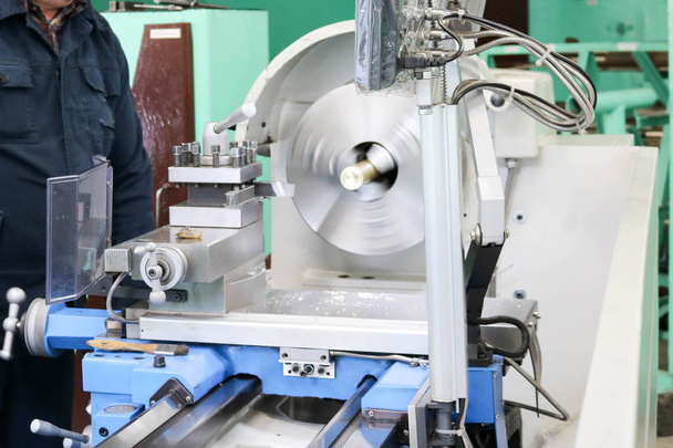 Un trabajador masculino trabaja en un torno de cerrajero de hierro metálico más grande, equipo para reparaciones, trabajos de metal en un taller en una planta metalúrgica en una producción de reparación
 - Foto, imagen