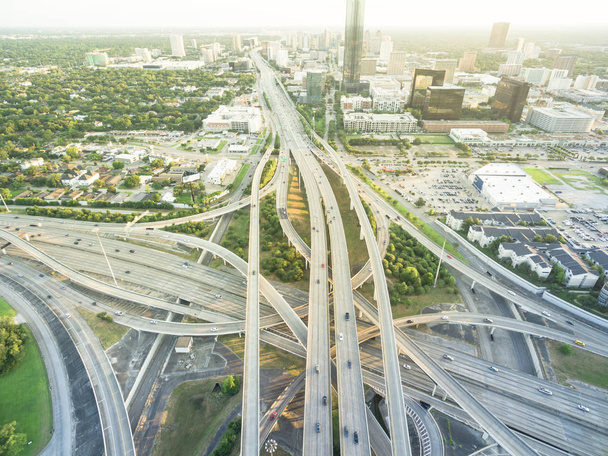 Aerial Interstate I-610 freeway massive intersection and Houston midtown skylines background. Stack interchange, elevated road junction overpass viaduct. Nightly degree vertical view metropolitan area - Photo, Image