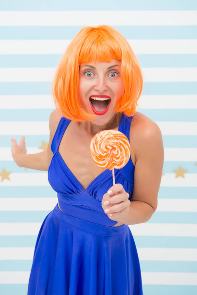 happy pinup model with lollipop in hand. Fashion girl with orange hair having fun. Cool girl with lollipop. Sexy woman. Crazy girl in playful mood. Sweet look. So much fun. Going crazy. Enjoy party - Foto, imagen