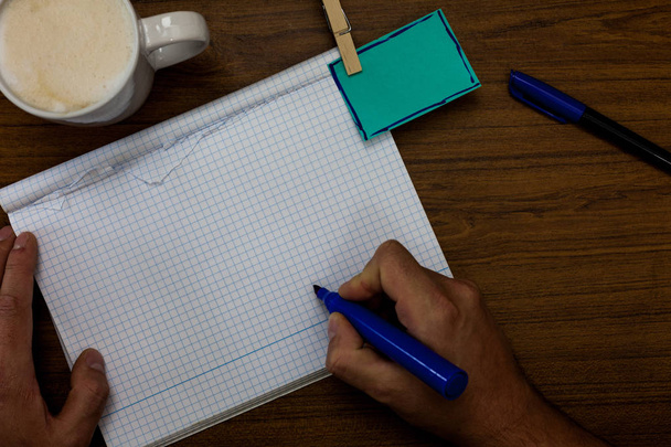 Design Geschäftskonzept leere Kopie Text für Web-Banner Werbematerial-Attrappe Vorlage Hand halten Stift Kaffeetasse blau Stift Büroklammer geschrieben Notiz auf holzigen Tisch - Foto, Bild