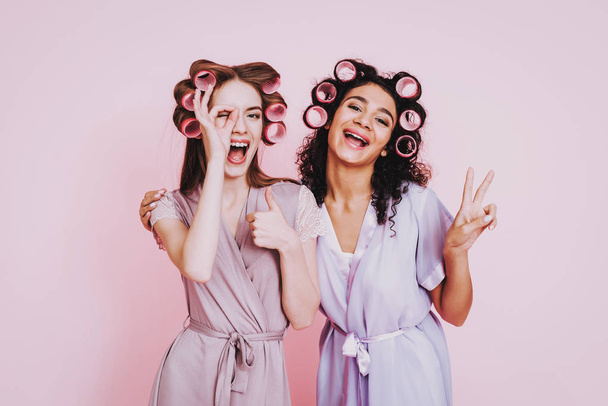Celebrating Women's Day. Pink Background. Two Emotional Women. Happy Emotions Woman. International Party. Beautiful Women. Womans Emotion. Girls with Champagne. Violet Bathrobes. Smiling Person. - Photo, image