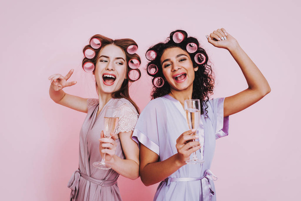 Glasses Champagne. Pink Background. Celebrating Women's Day. Two Emotional Women. Happy Emotions Woman. International Party. Beautiful Girl. Womans Emotion. Girls with Champagne. Women in Bathrobes. - Фото, зображення