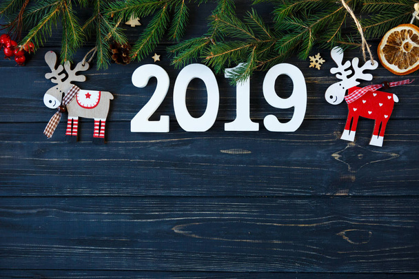 witte houten nummers 2019 met decor, takken van een spar op de grijze houten tafel. Nieuwjaar en Kerstmis decoratie concept - Foto, afbeelding