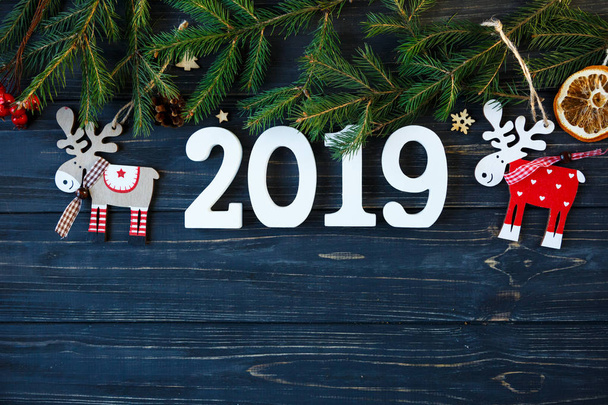 números de madeira branco 2019 com decoração, ramos de abeto na mesa de madeira cinza. Ano Novo e conceito de decoração de Natal
 - Foto, Imagem