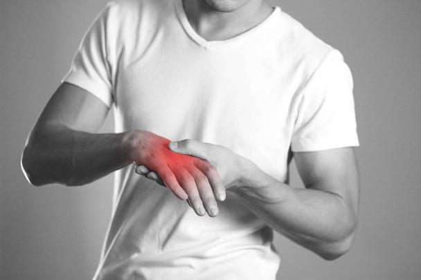 A man holding hands. Pain in the wrist. The hearth is highlighted in red. Close up. Isolated background. - Fotoğraf, Görsel