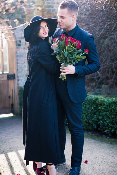 Charming couple in black with beautiful roses outdoor - Valokuva, kuva