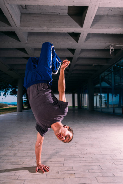 Sportive man training parkour handstand outdoor - Photo, image