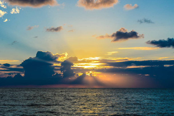 Värikäs auringonlasku taivas yli meren pinnan
 - Valokuva, kuva