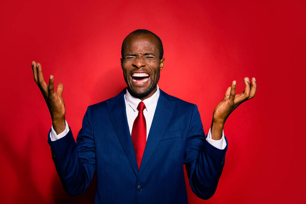 Portrait of tense chic classy confident analyst sale manager man in tie trendy tux tuxedo formalwear close eyes isolated on red vivid background hold hands palms up make evil grimace face - Fotó, kép