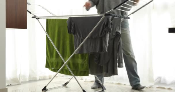 Καλλιέργεια γυναίκα κρεμασμένα ρούχα στο στεγνωτήριο στο σπίτι - Πλάνα, βίντεο