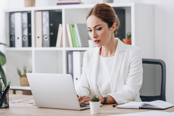 mujer de negocios profesional seria en ropa formal trabajando con el ordenador portátil en la oficina
 - Foto, Imagen