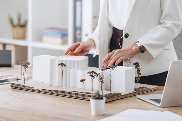 cropped view of female architect with house model at workspace - Fotografie, Obrázek