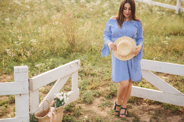 Pregnant woman in blue dress hold knitted had in hands - Foto, imagen