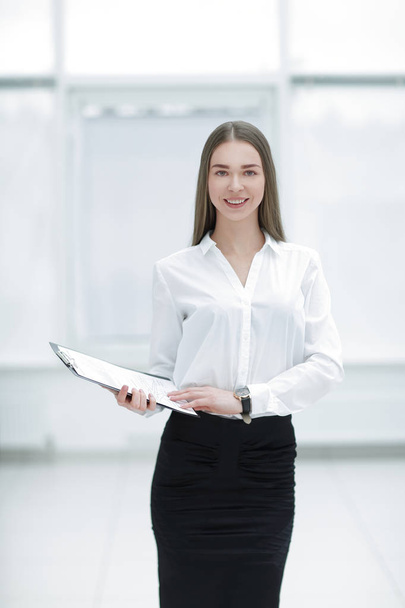 Executive business woman with clipboard against the background of bright office - Fotografie, Obrázek
