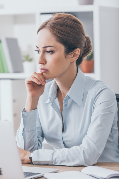 thoughtful adult businesswoman sitting at workplace - Foto, afbeelding