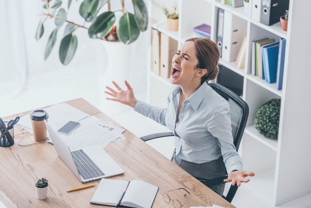 visão de alto ângulo da mulher de negócios estressada gritando no local de trabalho
 - Foto, Imagem