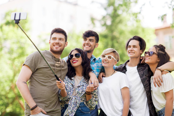 friends taking picture by selfie stick at summer - Foto, Imagen