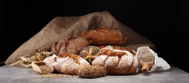 Több féle kenyeret és kenyér tekercs a fedélzeten a fenti. Konyha vagy a pékség, plakát tervezés. - Fotó, kép