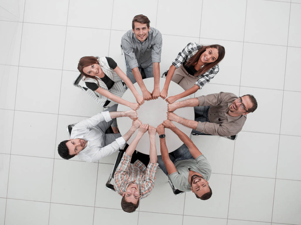 smiling business team folded their hands forming a circle - Fotoğraf, Görsel