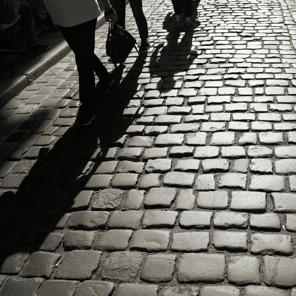 Gölge cobblestones arka ışık içinde yaklaşmakta olan kişilerin  - Fotoğraf, Görsel