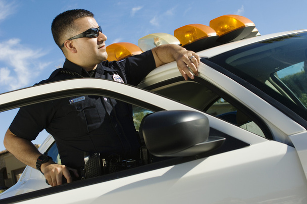 Police Officer Leaning On Patrol Car - Foto, imagen