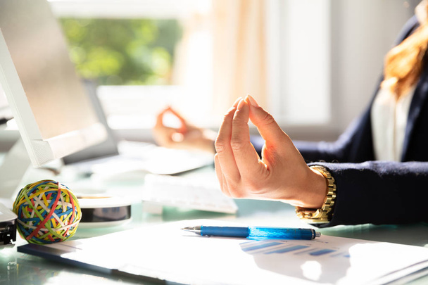 Close-up Of A Businesswoman's Hand Meditating In Office - 写真・画像