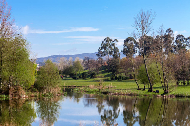Lake of vijver gevormd door de Pelhe-rivier in Parque da Devesa Urban Park in Vila Nova de Famalicao, Portugal. Gebouwd in de buurt van het centrum van de stad  - Foto, afbeelding