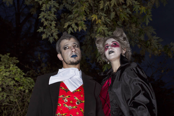 Halloween párty, mladý pár oblečená pro halloween. Maskovaný na tmavém pozadí. - Fotografie, Obrázek