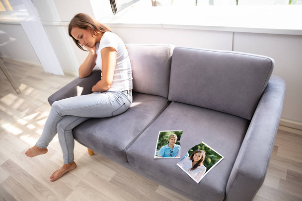 破れた写真のソファに座っている孤独な女性 - 写真・画像