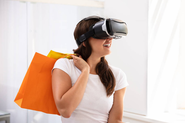 Smiling Young Woman Using Virtual Reality Device For Shopping Experience At Home - Fotoğraf, Görsel