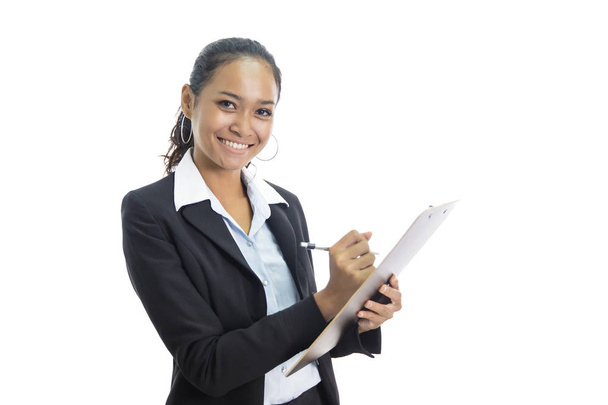 young busineswoman writing report while standing and smiling - Фото, изображение