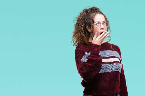 Beautiful brunette curly hair young girl wearing glasses over isolated background bored yawning tired covering mouth with hand. Restless and sleepiness. - Photo, Image