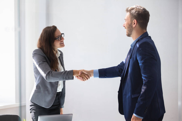 Smiling Young Businesswoman Shaking Hands With Her Partner In Office - Φωτογραφία, εικόνα