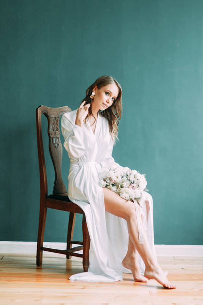 Conceptual wedding, the morning of the bride in the European style. Boudoir dress and a bouquet of flowers, fees in the interior Studio. - Photo, Image