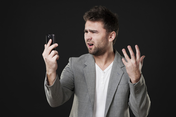 Frustrated man with mobile phone - Φωτογραφία, εικόνα