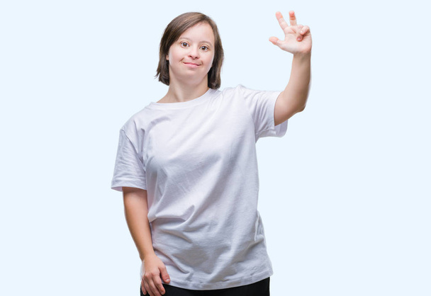 Giovane donna adulta con sindrome di Down su sfondo isolato mostrando e indicando con le dita il numero tre, sorridendo fiducioso e felice
. - Foto, immagini