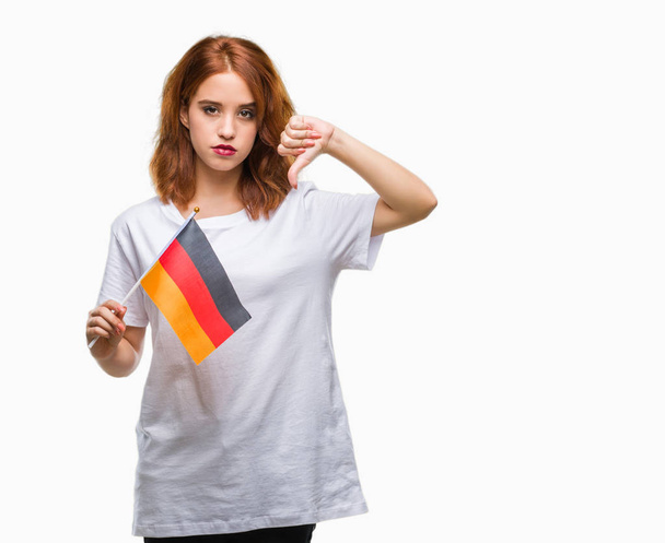 Young beautiful woman holding flag of germany over isolated background with angry face, negative sign showing dislike with thumbs down, rejection concept - Photo, image
