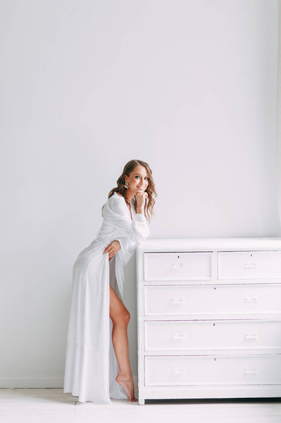 Conceptual wedding, the morning of the bride in the European style. Boudoir dress and a bouquet of flowers, fees in the interior Studio. White minimalism for the bride - Foto, Imagem