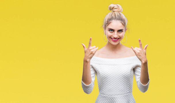 Young beautiful blonde and blue eyes woman over isolated background shouting with crazy expression doing rock symbol with hands up. Music star. Heavy concept. - Foto, Bild