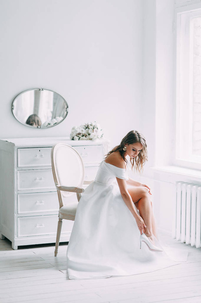 A concept wedding, contemporary European bride. Bouquet of flowers, fees in the interior Studio. Ideas for a minimalist wedding, white color - Photo, Image