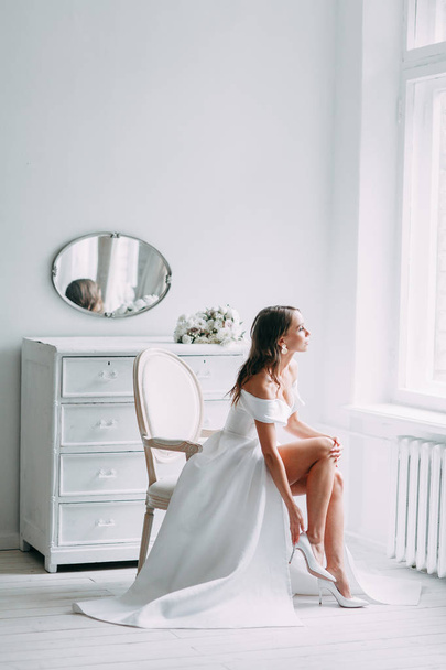A concept wedding, contemporary European bride. Bouquet of flowers, fees in the interior Studio. Ideas for a minimalist wedding, white color - Foto, afbeelding