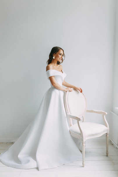 A concept wedding, contemporary European bride. Bouquet of flowers, fees in the interior Studio. Ideas for a minimalist wedding, white color - Fotó, kép