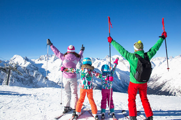 счастливая семья в горнолыжном снаряжении на горнолыжном курорте
 - Фото, изображение