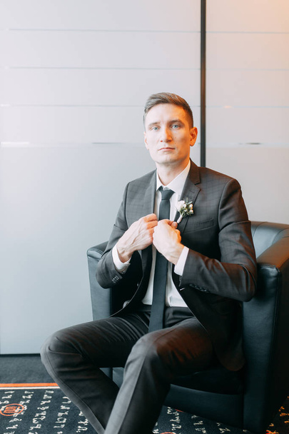 Stylish minimalism in the image of the groom. Black color and European wedding. The preparations of the groom, hotel - Фото, зображення
